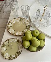 Group shot showing Stangl plates, bowl with apples, cut-glass vases, decanter, two-tier stand