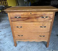 Front view of three-drawer dresser showing hardware and keyholes