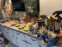 All items on countertop including wood turkey, ceramic turkey, wicker cornucopia, leaf dishes, scarecrow, runner, pilgrim figures
