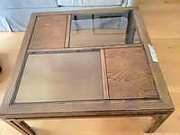 Top view of square wood coffee table showing glass inset panels