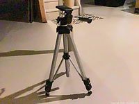 Full view of tripod standing on floor, legs extended