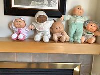 Five dolls on mantel showing full lot