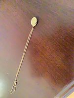 Full view of gold-tone locket necklace laid flat showing chain length and clasp