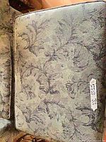 Armchair seat cushion showing green damask fabric