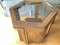Angled view showing hexagonal oak end table with glass inset top