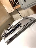 JVC silver DVD player with remote and power cable on top