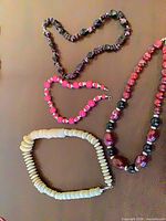 All four bead necklaces laid out to show styles and clasp types