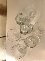 Eight assorted clear glass candle holders photographed from above to show shapes