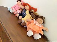 All five dolls lying on wooden surface