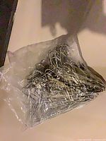 Bag containing stack of silver chrome metal wire hangers