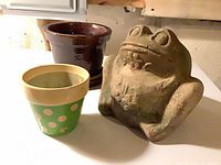 front view of frog planter, brown pot, green polka-dot pot