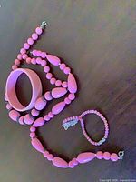 Necklace, bracelet and bangle arranged together displaying shape and color