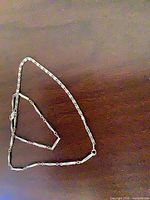 Full view of silver-tone chain laid out showing link pattern and clasp