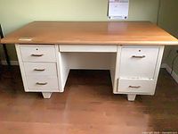 Front view of desk showing natural wood top, white base, drawer configuration