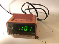 Front view showing green LED display at 1:01 pm and Spartus branding