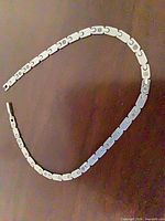 Full view of stainless steel flat link necklace chain arranged in curve