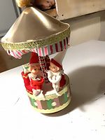 Full view of carousel music box showing elves, canopy and base