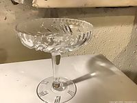 Side view of clear cut crystal pedestal compote showing stem, base and scalloped rim