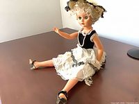 Full doll seated showing entire outfit and shoes