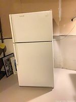Full front view of Whirlpool top-freezer refrigerator showing overall condition and color