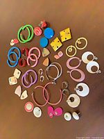 Top-down view of entire assortment showing quantity and variety of hoop and stud earrings
