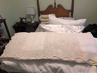 Bedspread folded on twin bed showing crochet pattern and scalloped edge