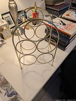 Full view of brass-tone metal wine rack on tabletop