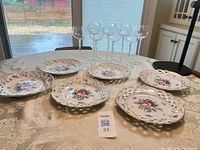 Overview of six porcelain plates and six wine glasses on table