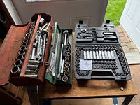 Overview of three open tool cases displaying sockets and wrenches