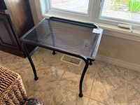 overall view of black metal mesh side table near window