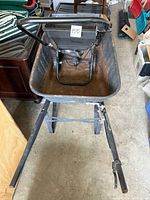 Top view of metal wheelbarrow showing rusted bucket and metal handles