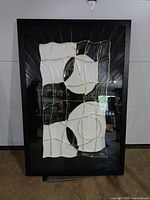 Full view of framed glass artwork showing abstract design and frame