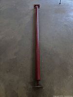 Full length of red adjustable steel jack post