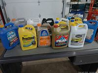 Front view showing 10 assorted antifreeze jugs on table