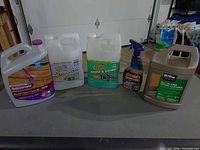 Five cleaning chemical containers lined on a table