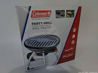 Front of boxed Coleman Party Grill showing product image and specifications