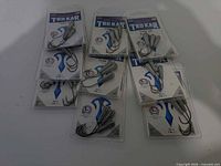 Nine sealed packs of Eagle Claw TroKar Tube Jigs on display