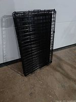 Dog crate folded flat leaning against wall