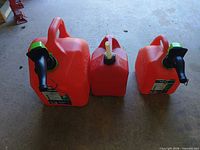 Three red Scepter fuel cans side by side