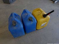 Three plastic fuel cans arranged side by side on floor