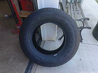 Full view of Goodyear Wrangler tire leaning against wall