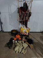 Group shot of all Halloween props on floor including ghoul, cauldron, pumpkins, limbs