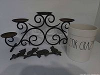 Lot overview showing candle holder, wall hook, crock