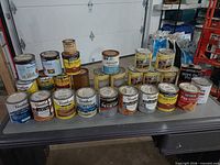 Wide view of entire lot of paint and stain cans on table