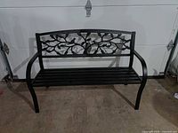 Front view of black metal bench with tree of life backrest