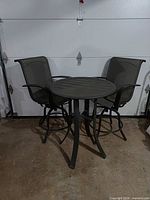 full view of round metal table with two swivel chairs
