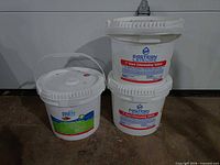 Three pool chemical buckets: two Eastern Leisure chlorine tablet buckets stacked beside one Poolife alkalinity balancer bucket