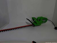 Full view of green Portland corded hedge trimmer with red blade