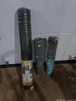 Three rolls of poultry fencing standing upright