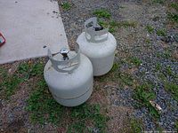 Two propane cylinders on ground